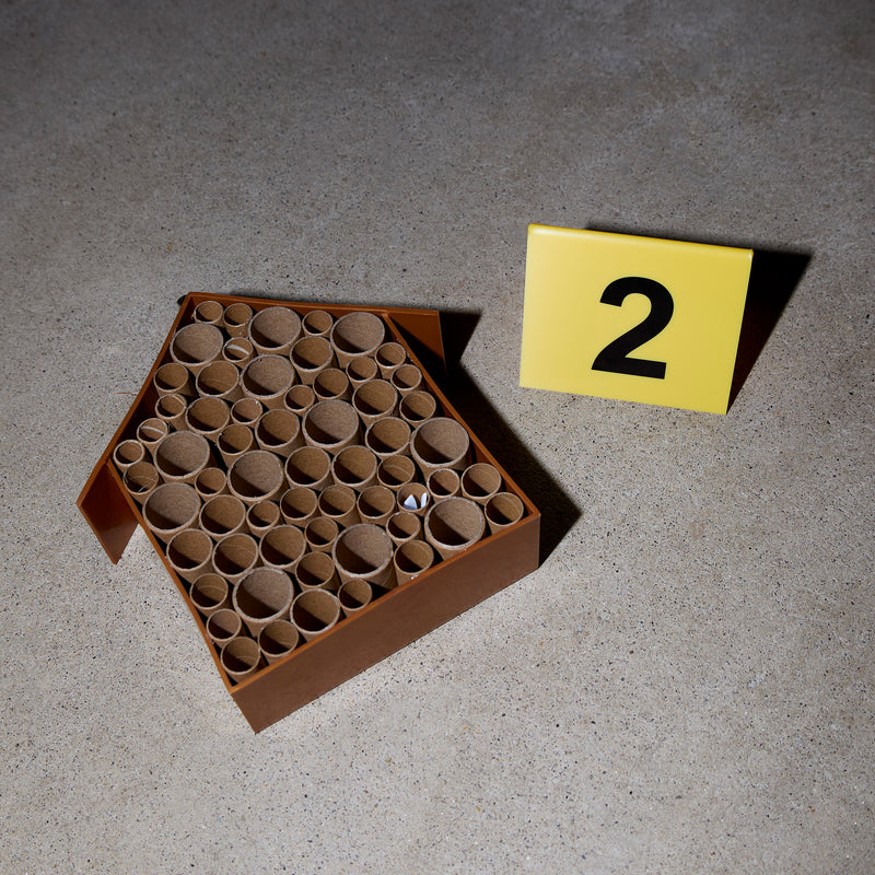 A wooden be house with cardboard tubes for bees to nest in