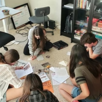 A team solving cases on Hunt A Killer while sitting on the floor