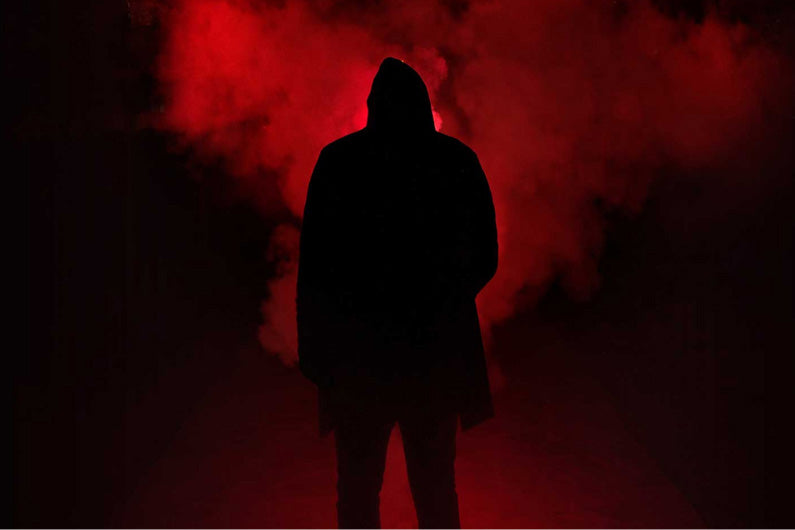 Mysterious silhouette on a black and red background with a smoke