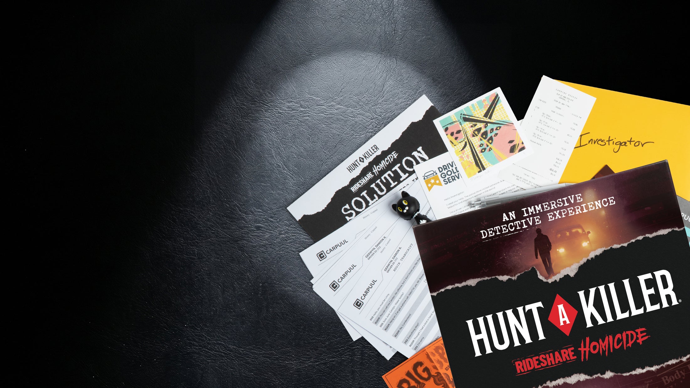 A detective's desk under a spotlight with a Hunt A Killer case box and scattered evidence